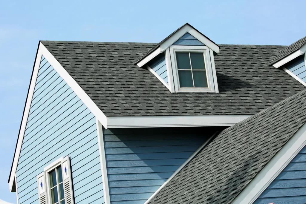 a blue house with a black roof and a white window