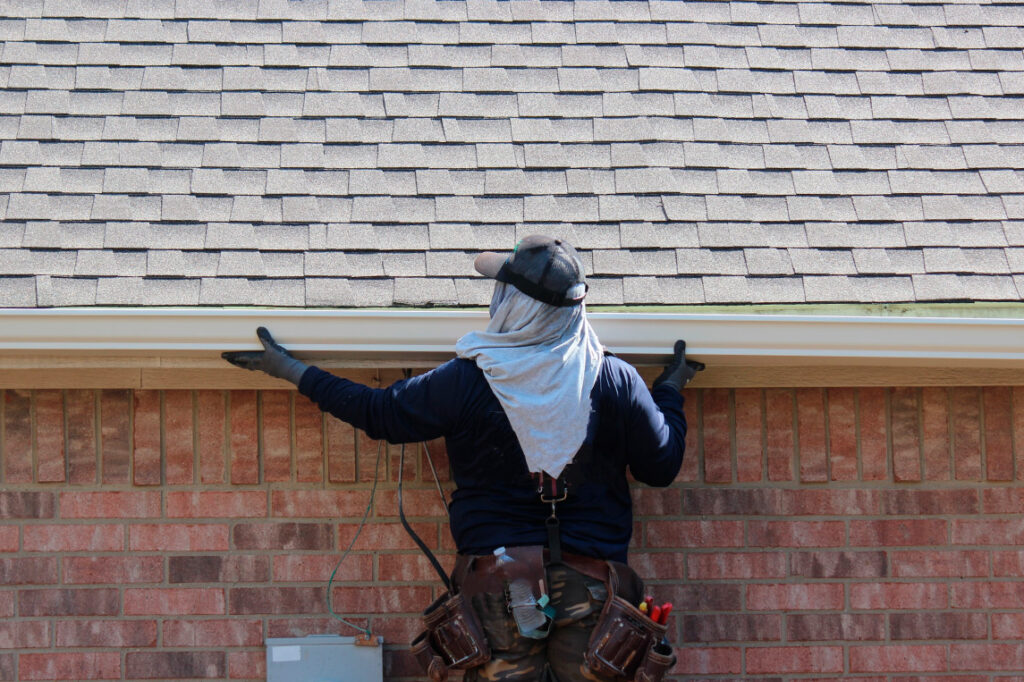 Gray roof - Repair and Replace the House Roof with Handyman with Tools and Pprotective equipment. Stand on the Roof with the Ssky Background. Cover image for Top 5 Signs It’s Time for Gutter Replacement